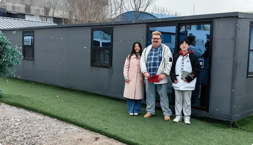 Visita de clientes frente a una casa modular negra